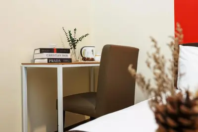 a desk with a chair and a table with books at MyCiti Hotel Kuala Lumpur - formerly known as Citin Hotel Masjid Jamek in Kuala Lumpur
