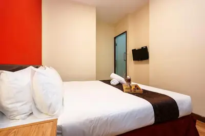 a bedroom with a white bed with a tray on it at MyCiti Hotel Kuala Lumpur - formerly known as Citin Hotel Masjid Jamek in Kuala Lumpur