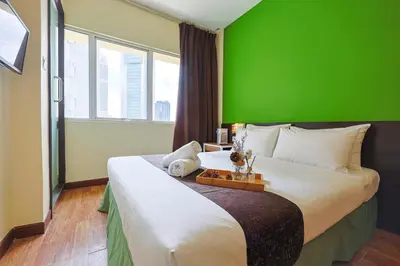 a bedroom with a large bed with a green wall at MyCiti Hotel Kuala Lumpur - formerly known as Citin Hotel Masjid Jamek in Kuala Lumpur