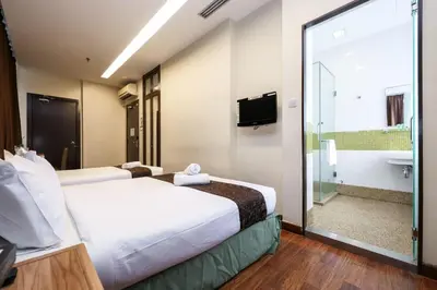 a hotel room with two beds and a sliding glass door at MyCiti Hotel Kuala Lumpur - formerly known as Citin Hotel Masjid Jamek in Kuala Lumpur