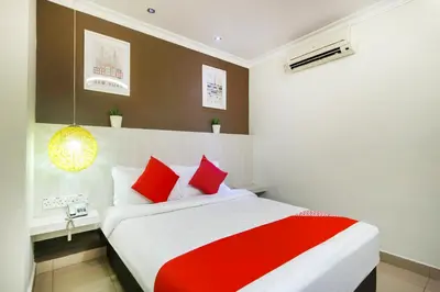 a bedroom with a bed with red and white pillows at OYO 761 City Hotel in Kuala Lumpur