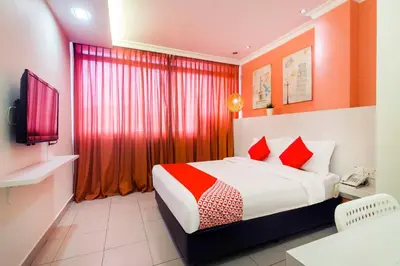 a hotel room with a bed with red curtains at OYO 761 City Hotel in Kuala Lumpur