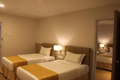 a hotel room with two beds and a mirror at NU Hotel @ KL Sentral in Kuala Lumpur