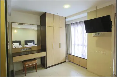 a room with a mirror and a tv and a bedroom at T Hotel Jalan Tar in Kuala Lumpur