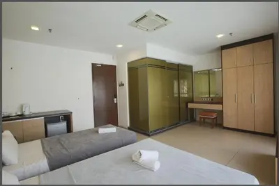 a large bedroom with two beds and a kitchen at T Hotel Jalan Tar in Kuala Lumpur