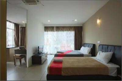 a hotel room with two beds and a window at T Hotel Jalan Tar in Kuala Lumpur
