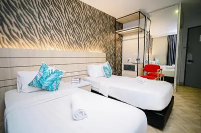 a hotel room with two beds and a mirror at Kingston Hotel 2 - Setapak in Kuala Lumpur