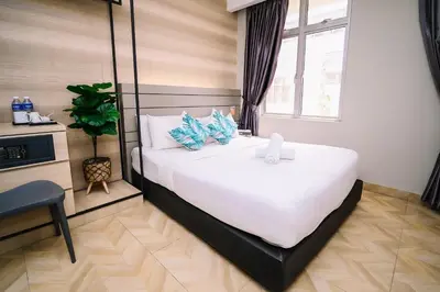 a bedroom with a large white bed with blue pillows at Kingston Hotel 2 - Setapak in Kuala Lumpur