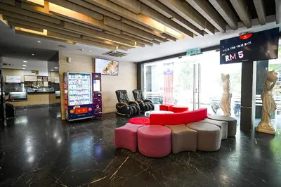 a lobby with a tv and a couch and chairs at Kingston Hotel 2 - Setapak in Kuala Lumpur