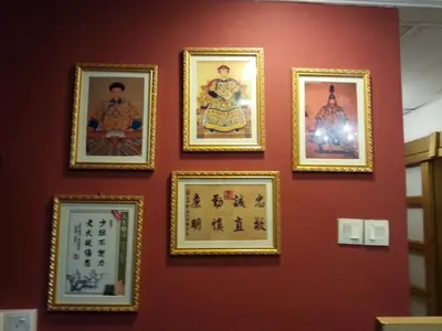a wall of chinese paintings on a red wall at City Inn Hotel in Kuala Lumpur