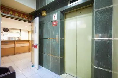 a hallway with two elevator doors in a building at Tang City Hotel, Petaling Street, Merdeka PNB 118 Tower in Kuala Lumpur