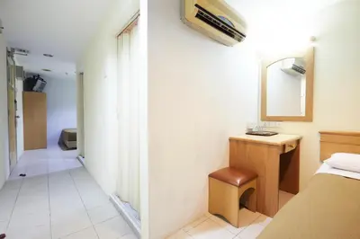 a bedroom with a bed and a desk and a mirror at Tang City Hotel, Petaling Street, Merdeka PNB 118 Tower in Kuala Lumpur