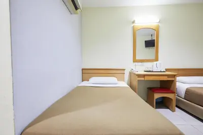 a small room with a bed and a mirror at Tang City Hotel, Petaling Street, Merdeka PNB 118 Tower in Kuala Lumpur