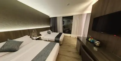 a hotel room with two beds and a flat screen tv at Flora by Crossroads Hotel in Kuala Lumpur