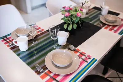 a table with plates and glasses and a vase of flowers at Vortex KLCC by Luxury Suites Asia in Kuala Lumpur