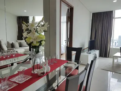 a living room with a table with a vase of flowers at Vortex KLCC by Luxury Suites Asia in Kuala Lumpur