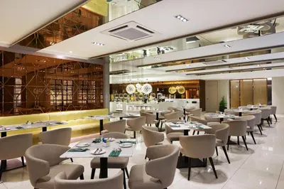 a restaurant with tables and chairs and a bar at Cosmo Hotel Kuala Lumpur in Kuala Lumpur