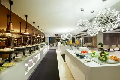 a restaurant with a buffet line with food on display at Cosmo Hotel Kuala Lumpur in Kuala Lumpur