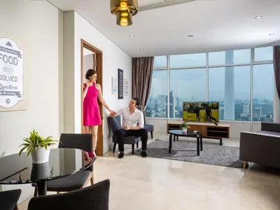 a woman standing next to a man in a living room at The Penthouse KLCC in Kuala Lumpur