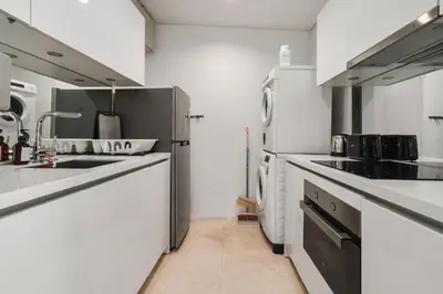 a kitchen with white counters and a sink at Vortex KLCC Apartments in Kuala Lumpur