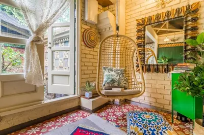 a room with a rattan chair and a window at Classic Malay House in KL City Centre in Kuala Lumpur