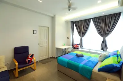 a bedroom with a bed and a chair and a window at Parkview Service Apartments in Kuala Lumpur