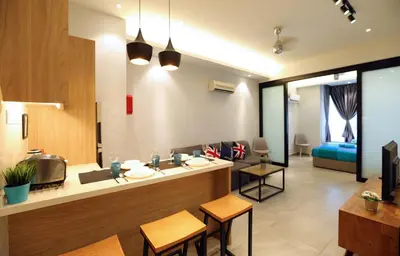 a kitchen and living room with a counter and chairs at Parkview Service Apartments in Kuala Lumpur