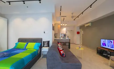 a bedroom with a bed and a couch and a tv at Parkview Service Apartments in Kuala Lumpur