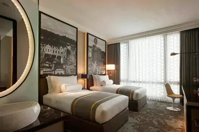 a hotel room with two beds and a bathroom at Hotel Stripes Kuala Lumpur, Autograph Collection in Kuala Lumpur
