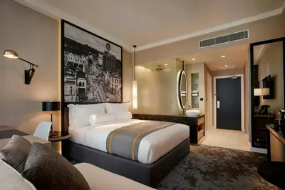 a hotel room with a bed and a bathroom at Hotel Stripes Kuala Lumpur, Autograph Collection in Kuala Lumpur