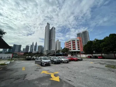 a parking lot with cars parked in front of a city at Akar Hotel Jalan TAR in Kuala Lumpur