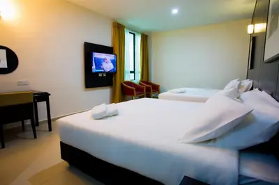 a hotel room with two beds and a desk at Akar Hotel Jalan TAR in Kuala Lumpur
