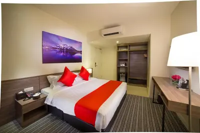 a hotel room with a large bed with red pillows at Riccarton Capsule Hotel in Kuala Lumpur