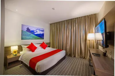 a hotel room with a large bed with red pillows at Riccarton Capsule Hotel in Kuala Lumpur