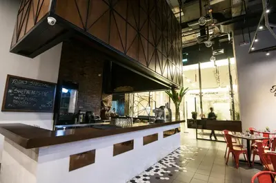 a restaurant with a bar with chairs and tables at Binjai 8 KLCC by PSM Luxury Suites in Kuala Lumpur