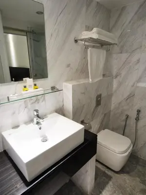 a bathroom with a sink and a toilet and a mirror at InnB Park Hotel in Kuala Lumpur