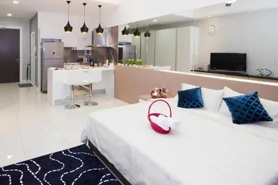 a bedroom with a white bed with a red purse on it at Five Senses Suite in M Suite KLCC in Kuala Lumpur