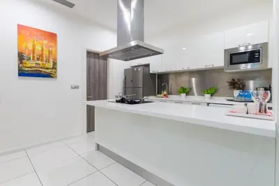 a kitchen with white counters and a stove top oven at Five Senses Suite in M Suite KLCC in Kuala Lumpur