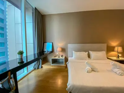 a bedroom with a white bed and a balcony at The Platinum Kuala Lumpur by LUMA in Kuala Lumpur