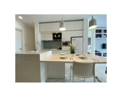 a kitchen with white cabinets and a table and chairs at The Platinum Kuala Lumpur by LUMA in Kuala Lumpur