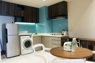 a kitchen with a table and a washing machine at D'Majestic Place by Widebed in Kuala Lumpur