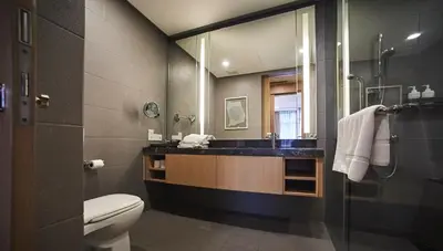 a bathroom with a toilet and a sink and a mirror at 188 Suites by NamaStay in Kuala Lumpur