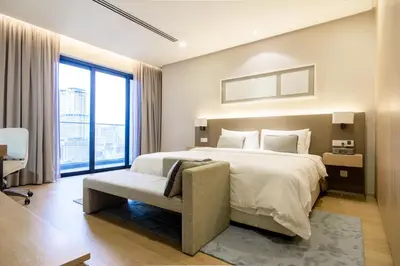 a bedroom with a large bed and a chair at 188 Suites by NamaStay in Kuala Lumpur