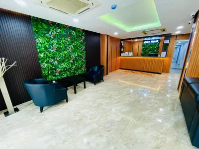 a lobby with a large green wall at Cozy Hotel@ KL Sentral in Kuala Lumpur