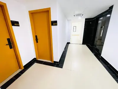 a hallway with yellow doors and black tile floors at Cozy Hotel@ KL Sentral in Kuala Lumpur