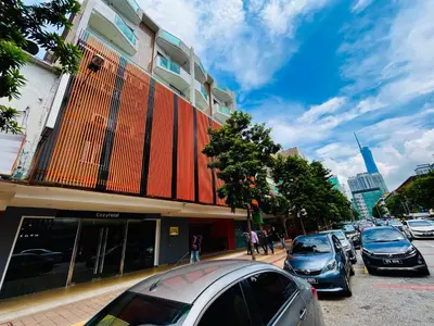 a street with cars parked in front of a building at Cozy Hotel@ KL Sentral in Kuala Lumpur