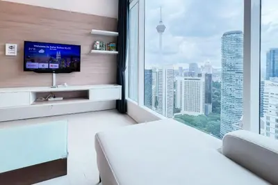 a bedroom with a large window with a tv at Soho Suites KLCC by Leala in Kuala Lumpur