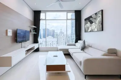 a living room with a white couch and a tv at Soho Suites KLCC by Leala in Kuala Lumpur