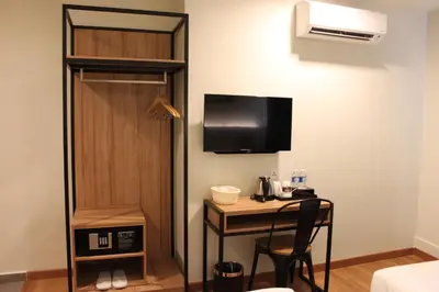 a hotel room with a desk and a tv and a room at BIG M Hotel in Kuala Lumpur