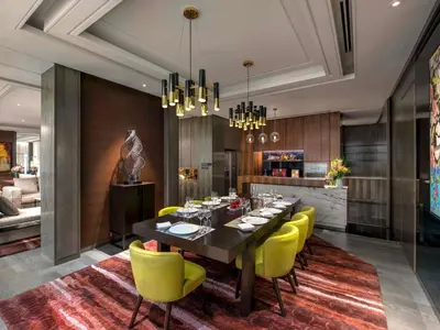 a dining room with a table and yellow chairs at Sofitel Kuala Lumpur Damansara in Kuala Lumpur